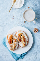 Fried Caramel Banana Sandwich with nuts and cream cheese on blue concrete background.