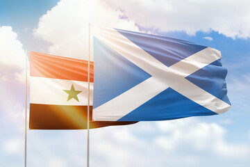 Sunny blue sky and flags of scotland and syria