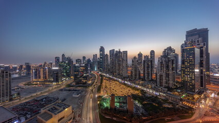 Naklejka na ściany i meble Panorama of Bay Avenue with modern towers residential development in Business Bay aerial day to night timelapse, Dubai