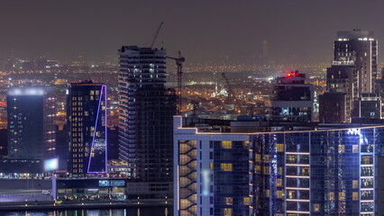 Obraz na płótnie Canvas Business Bay Dubai skyscrapers with water canal aerial night timelapse.