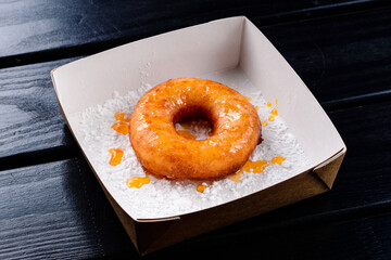 one doughnut in a street food box