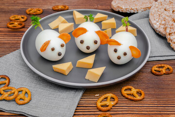 Small chicken eggs mouse,mice with ears of carrot,cheese on plate,creative, fun food,healthy lunch snack idea for kids party. Menu for spooky Halloween dessert treats, edible cute rat selective focus