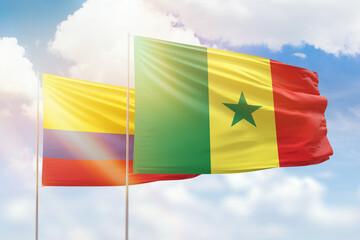 Sunny blue sky and flags of senegal and colombia