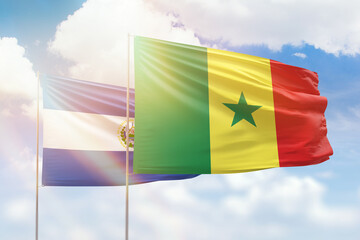 Sunny blue sky and flags of senegal and el salvador