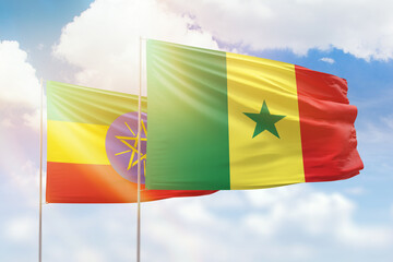 Sunny blue sky and flags of senegal and ethiopia