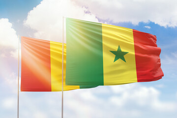 Sunny blue sky and flags of senegal and guinea