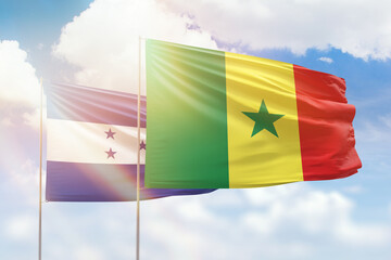 Sunny blue sky and flags of senegal and honduras
