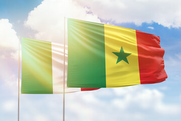 Sunny blue sky and flags of senegal and italy