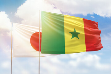 Sunny blue sky and flags of senegal and japan