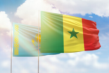Sunny blue sky and flags of senegal and kazakhstan