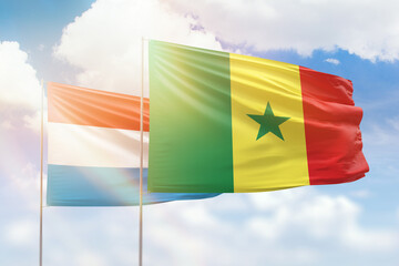 Sunny blue sky and flags of senegal and luxembourg