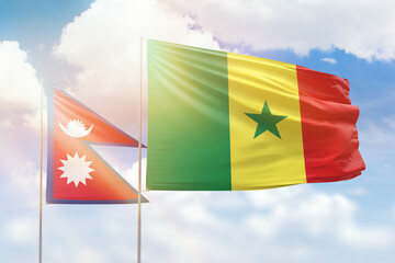 Sunny blue sky and flags of senegal and nepal