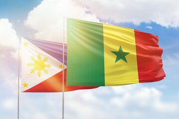 Sunny blue sky and flags of senegal and philippines
