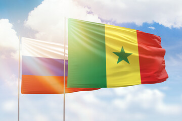 Sunny blue sky and flags of senegal and russia