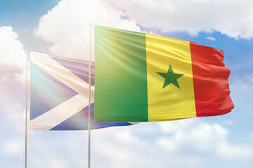 Sunny blue sky and flags of senegal and scotland