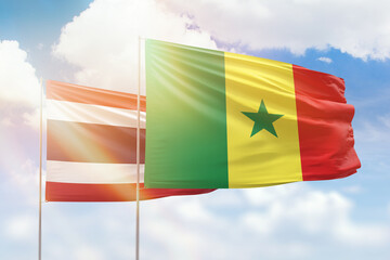 Sunny blue sky and flags of senegal and thailand