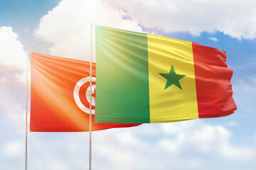 Sunny blue sky and flags of senegal and tunisia
