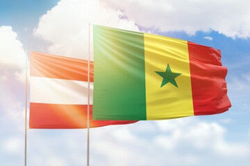 Sunny blue sky and flags of senegal and austria