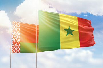 Sunny blue sky and flags of senegal and belarus