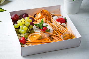 cheese plate a box with a set of cheeses for food delivery with cheese, bread sticks
