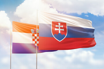 Sunny blue sky and flags of slovakia and croatia