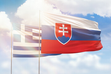 Sunny blue sky and flags of slovakia and greece