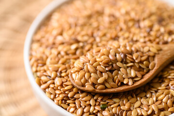 Golden flax seed or linseed in bowl with spoon, Close up