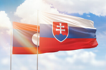 Sunny blue sky and flags of slovakia and laos