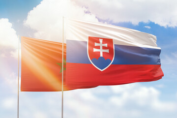 Sunny blue sky and flags of slovakia and morocco