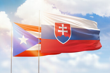Sunny blue sky and flags of slovakia and puerto rico