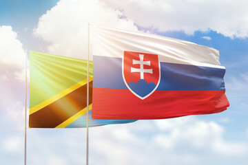 Sunny blue sky and flags of slovakia and tanzania