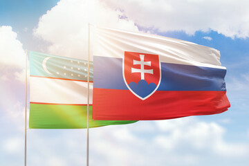 Sunny blue sky and flags of slovakia and uzbekistan