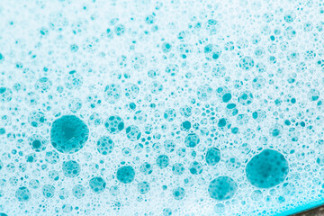 Blue water with white foam bubbles. Foam Water Soap Suds.Texture Foam Close-up. blue soap bubbles...