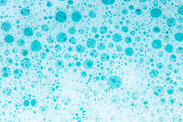Blue water with white foam bubbles.Cleanliness and hygiene background. Foam Water Soap Suds.Texture...