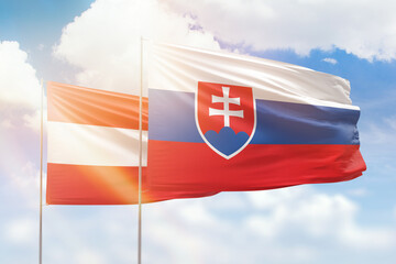 Sunny blue sky and flags of slovakia and austria