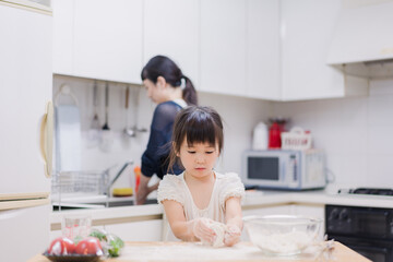 料理を手伝う女の子とお母さん