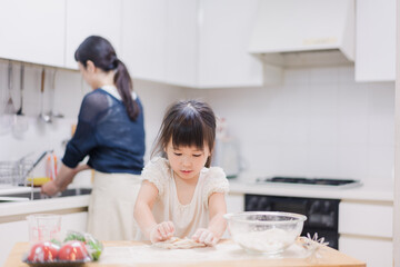 料理を手伝う女の子とお母さん