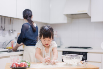 料理を手伝う女の子とお母さん