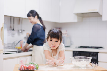 料理を手伝う女の子とお母さん