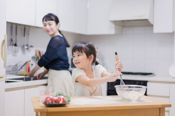 Obraz na płótnie Canvas 料理を手伝う女の子とお母さん