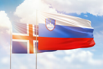Sunny blue sky and flags of slovenia and iceland