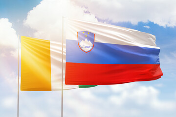 Sunny blue sky and flags of slovenia and ivory coast