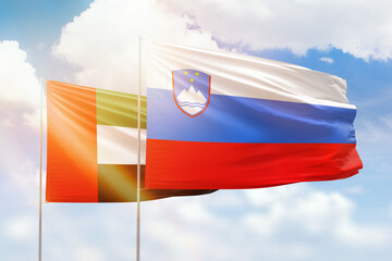 Sunny blue sky and flags of slovenia and uae