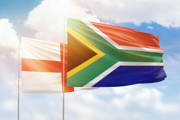 Sunny blue sky and flags of south africa and england