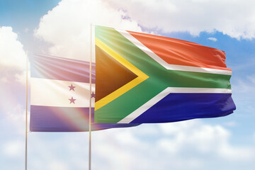 Sunny blue sky and flags of south africa and honduras