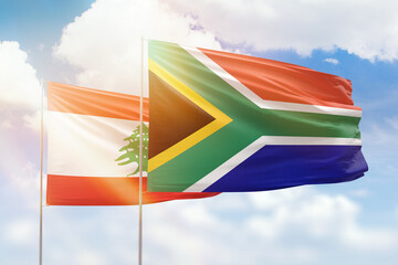 Sunny blue sky and flags of south africa and lebanon