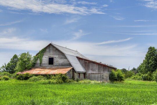 A large barn in a field of green grass