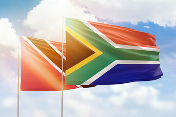 Sunny blue sky and flags of south africa and trinidad and tobago