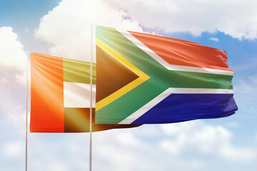 Sunny blue sky and flags of south africa and uae