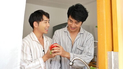 Asian two Man hands wash cleaning fresh vegetable in kitchen. Happy Asian gay couple homosexual cooking together in kitchen wash vegetable organic salad healthy home cook. LGBTQIA lifestyle concept